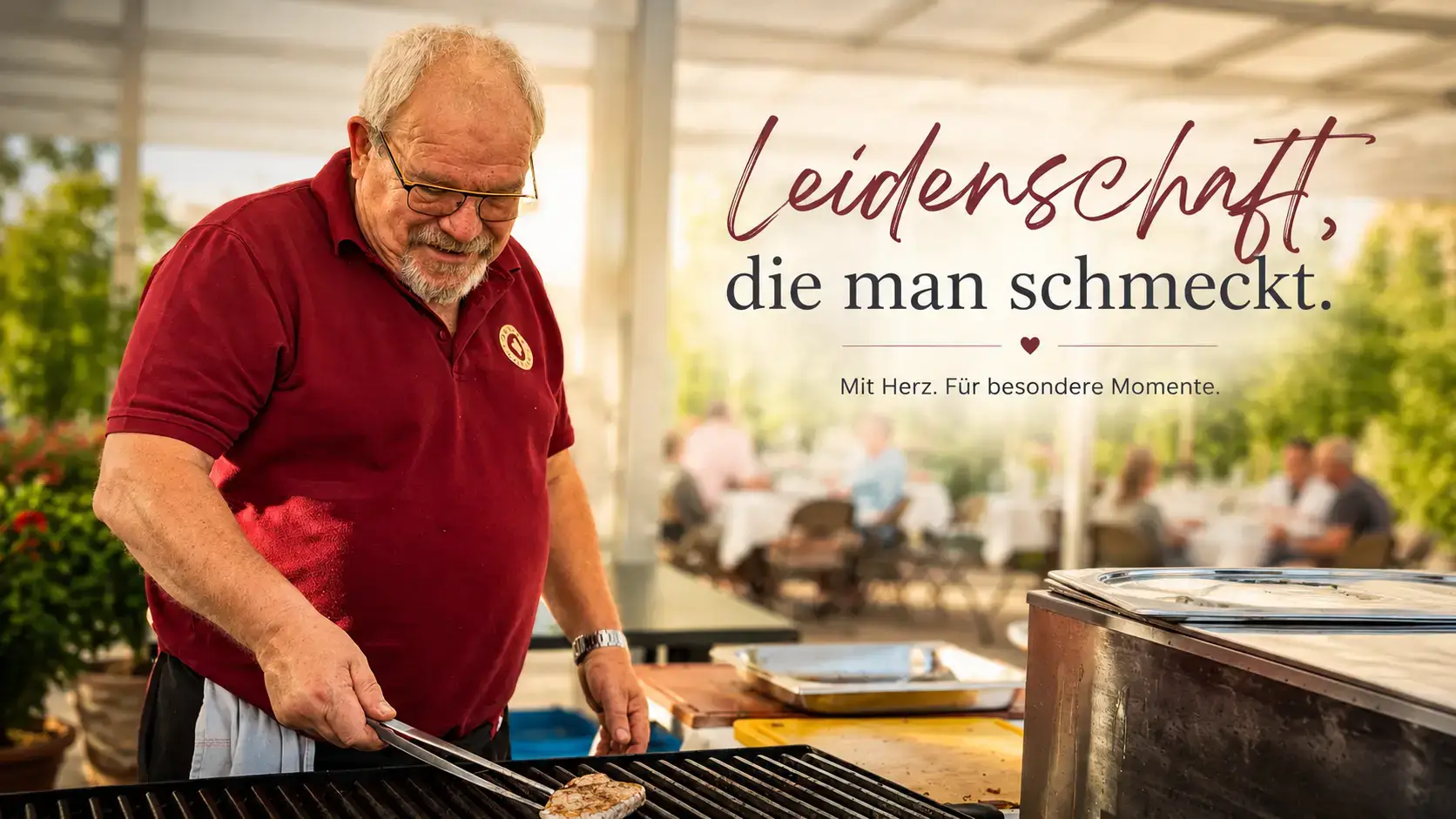 Antoine Stampfler im weinroten Polo wendet mit der Zange ein Stück Fleisch auf dem Grill, dahinter Gäste an gedeckten Tischen