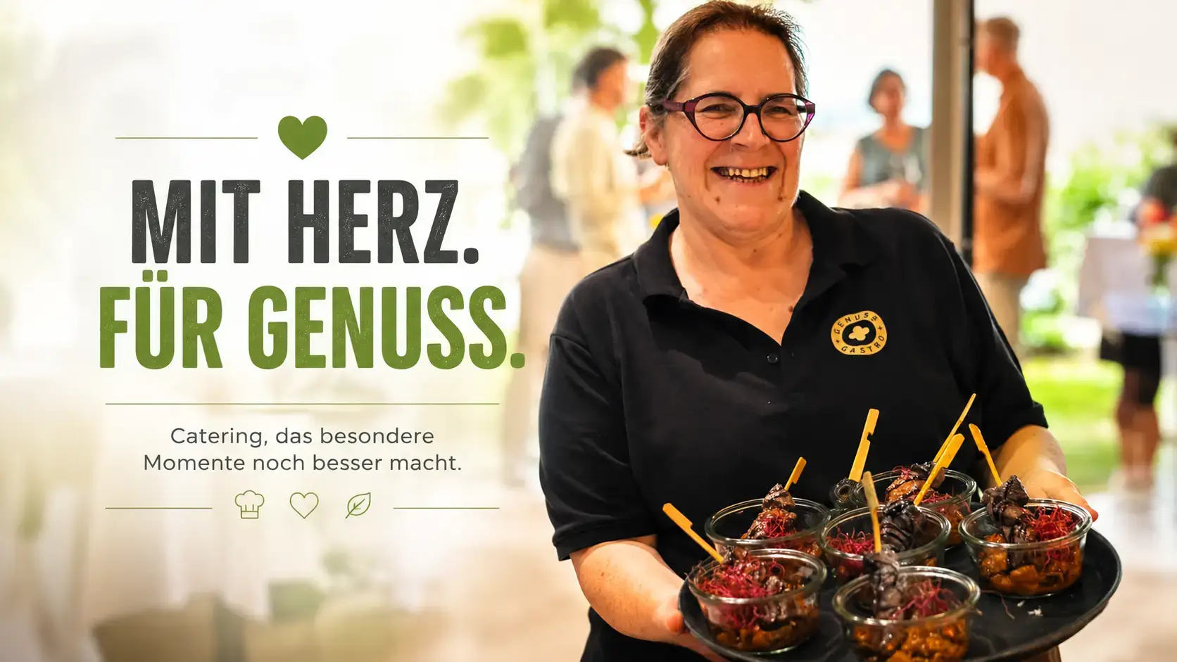 Beatrice Gasser im schwarzen Polo trägt ein Tablett mit Dessertgläschen, dahinter Gäste am Apéro